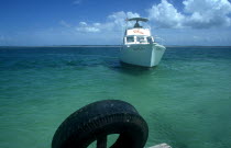 Deep sea fishing boat approaching jetty in clear light blue water