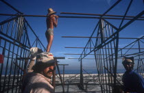 Construction workers erecting metal framework for stalls during the Carnival on the Malecon