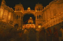 Dirwali festival  crowds of worshippers outside temple illuminated at night.