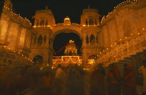 Dirwali festival  crowds of worshippers outside temple illuminated at night.