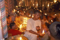 Dirwali festival  crowds of worshippers holding lighted candles inside temple.