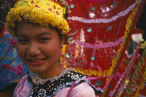 Girl dancer at hill tribe event in yellow  pink and red costume.  Head and shoulders shot.