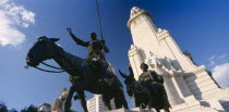 Plaza de Espana.  Angled view of the statues of Miguel de Cervantes with Don Quixote on his horse and Sancho Panza on a donkey  in the foreground  seen from below.