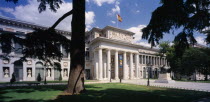 Museo del Prado.  Neo-classical building designed by Juan de Villanueva in 1785  entrance and facade seen between trees in the foreground.