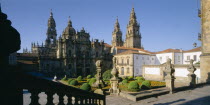 Cathedral  gothic exterior and spires partly seen above roof tops  stone balustrade in shadow in the foreground.