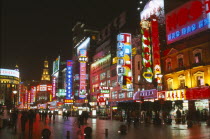 Busy pedestrianised street with neon signs and advertising hoardings illuminated at night. Nanjing Road.