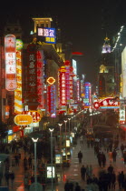 Busy pedestrianised street with neon signs and advertising hoardings illuminated at night. Nanjing Road.