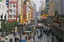 Pedestrianised street crowded with shoppers and lined with advertising hoardings and neon signs.   Nanjing Road.