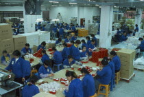 Female workers on floor of packaging factory.