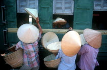 Traditional conical  straw hats being sold to train passengers at Hue station.