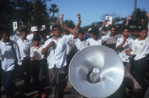 Anti Khmer Rouge and Samphon demonstration on the road to the airport.  Crowds with loud speaker.