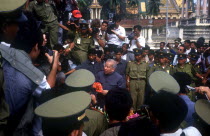 Sihanouk surrounded by crowds  journalists and troops at the Silver Pagoda.