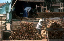 Firewood seller unloading bundles of firewood from a truck.