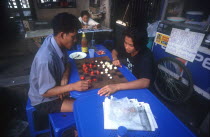 Couple playing a board game at a streetside cafe.