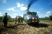 Area South of Danang.  Wounded soldier being put on a red cross helicopter during the main dust off.