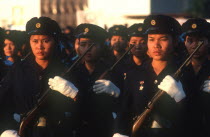 Air Lao workers in militia uniform at the Fifth Anniversary Parade carrying rifles.