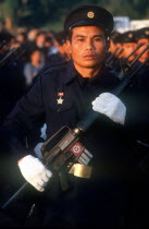 Electricity worker in militia uniform on parade carrying a USM M16 machine gun.