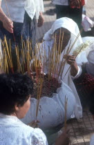 Wesak Festival.  Women lighting incense.