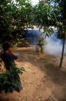 Young boy putting his fingers in his ears to block out the sound of firecrackers during Tet festival.