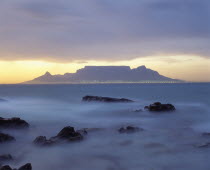 View of Table Mountain at dawn taken from Bloubergstrand shore line with heavy mist.