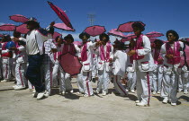 Coon Carnival  procession of men in colourful clothing.