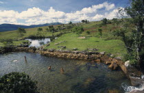 MacMac pools with people bathing grassland behind.