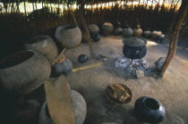 Simunye Lodge.  Interior of beer making hut with large vessels and pot on an open fire.