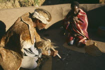 Basotho Cultural Village.  Local man consulting a Diviner using stones.