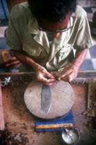 Detail of worker rolling a cigar in factory