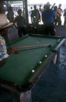 Men playing Pool while other men look on