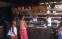 General Store with store person and customers standing at counter with weighing scales on