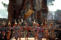 Temple dancers performing below a statue of Buddha in the ruins of the old capital near Bangkok.