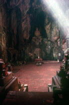 Cave Temple in the Marble Mountains.  Looking towards altar and seated Buddha above set into rockface.