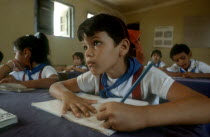 Children in classsroom writing whilst looking toward top of the class