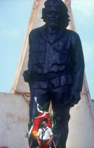 Young child at memorial day with statue of Che Guevara behind