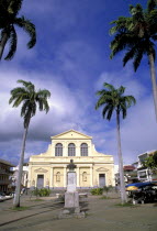 Church in small square in Poite-a-Pitre with coconut palm trees and a bust in front
