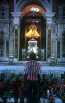 Sorlano Church interior with worshiper standing at the altar