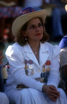 Seated woman dressed in white with medals pinned to the front of her jacket