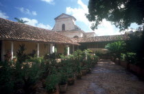 View over plant lined courtyard toward church building
