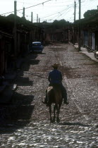 Man riding horse on cobbled street