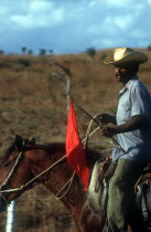 Man on horseback carrying red flag