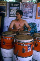 Drummer sitting behind large red and white drums