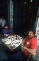 Bodequita del Medio Bar with two men sitting at a table covered in semi finnished plates of rice  beans and meat