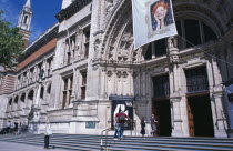 Kensington. Victoria and Albert Museum. View from steps towards main entrance with flag advertising Vivenne Westwood exhibition hanging above entrance.