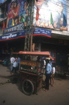 Street vendor with a covered stall set on a handcart.