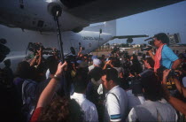 Crowds of press clustering around UN soldiers as they arrive at the airport.
