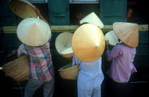 Vietnam, Hue, Women selling hats to train passengers from platform