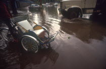 Street near the Royal Hotel flooded after the monsoon rains.  Car  truck and rickshaw surrounded by water.