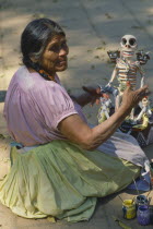 Woman making skeleton figure for Day of the Dead.