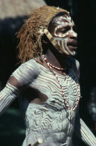 Kikuyu tribesman wearing head dress and white body paint.